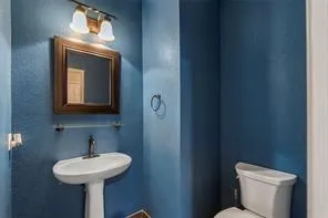 a bathroom with a toilet sink and mirror