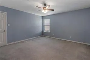 an empty room with windows and ceiling fan