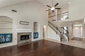 a living room with wooden floor and a fireplace