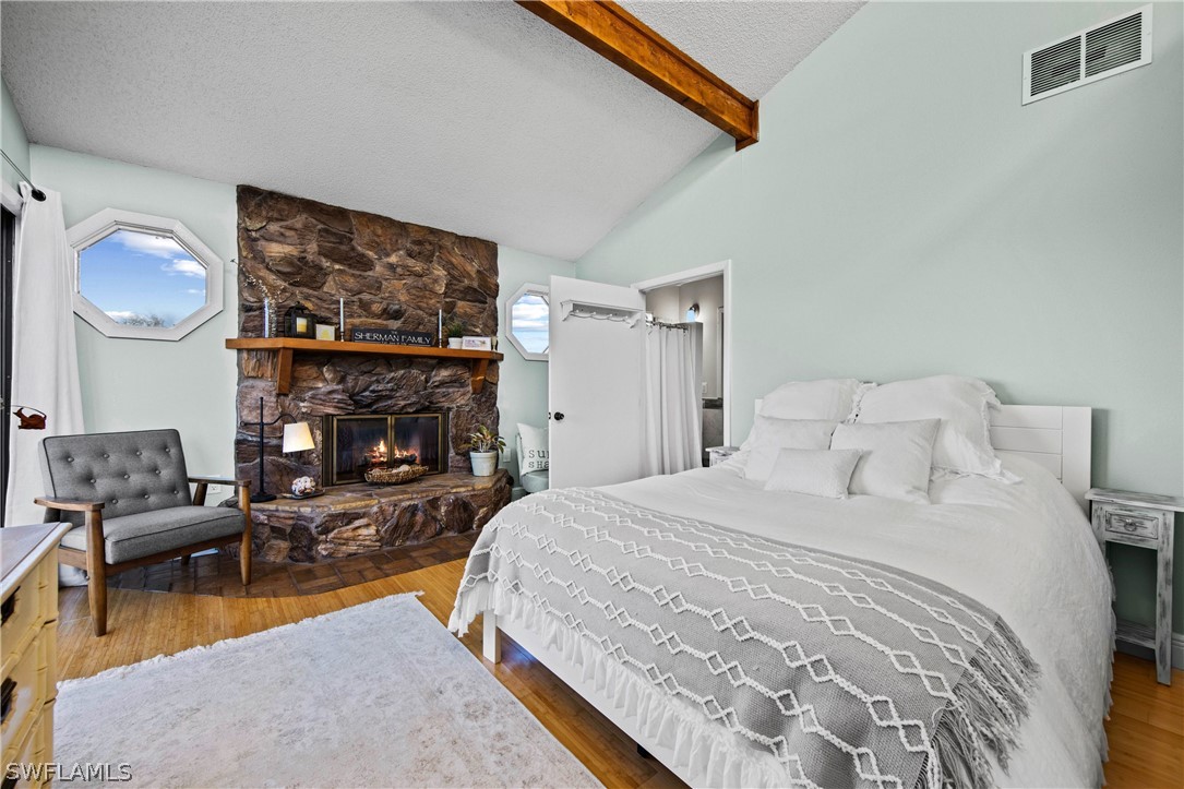 705 Rabbit Road Sanibel, FL 33957 - Photo 12 of 35 a spacious bedroom with a bed a couch and a fireplace
