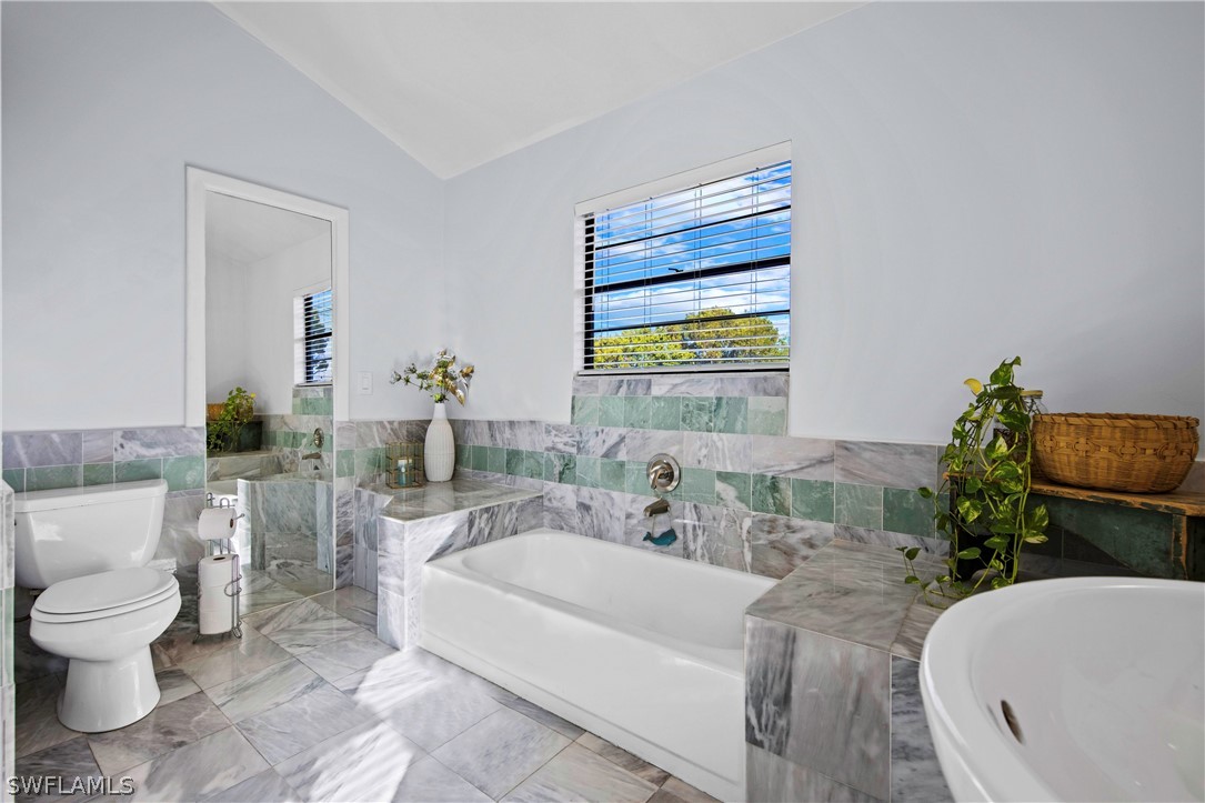 705 Rabbit Road Sanibel, FL 33957 - Photo 17 of 35 a bath room with a toilet a sink and a bath tub