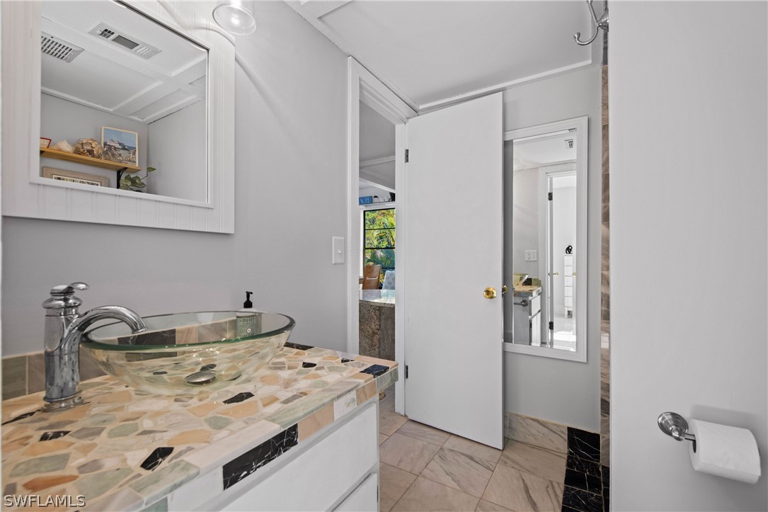 705 Rabbit Road Sanibel, FL 33957 - Photo 22 of 35 a bathroom with a sink and a mirror