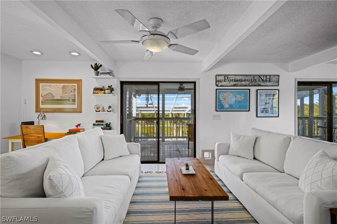 705 Rabbit Road Sanibel, FL 33957 - Photo 10 of 35 a living room with furniture ceiling fan and a rug