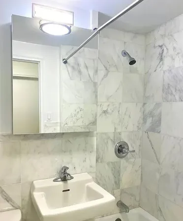 a bathroom with a sink a mirror and shower