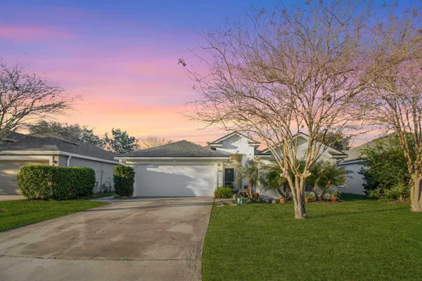 a view of a yard in front of a house with a large tree