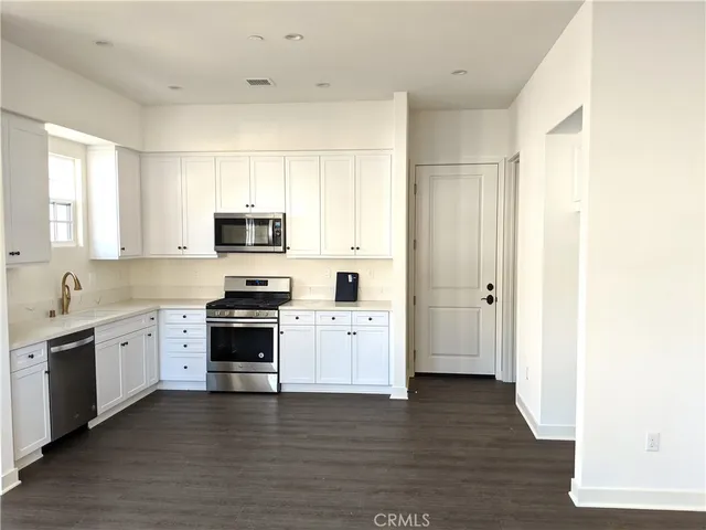 a kitchen with a sink cabinets and wooden floor