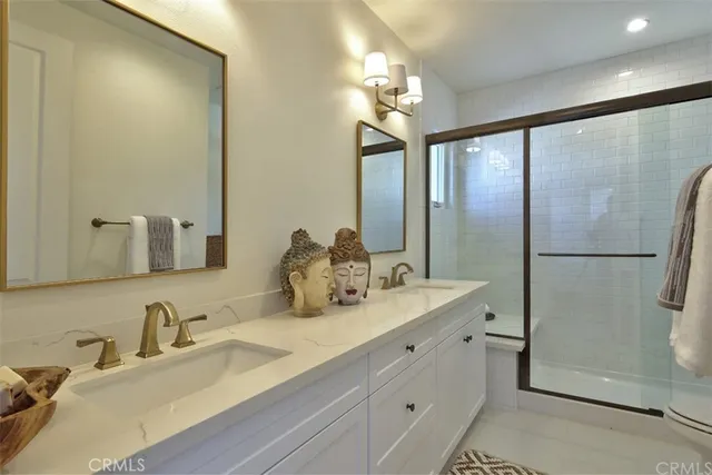 a bathroom with double vanity and a mirror