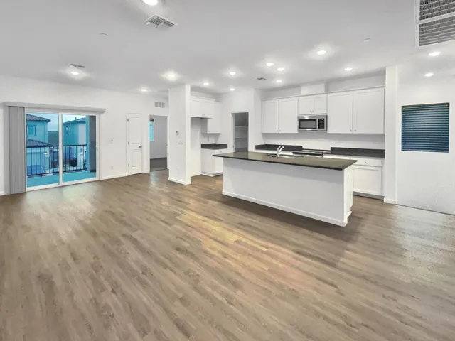 a view of kitchen with kitchen island sink stainless steel appliances and cabinets