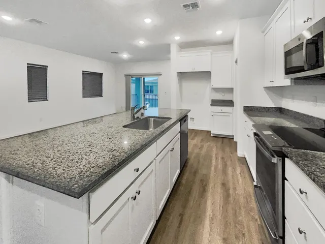 a kitchen with stainless steel appliances granite countertop a sink stove and oven