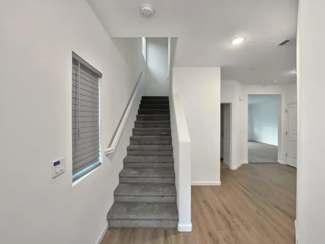 a view of a hallway with wooden floor and entryway