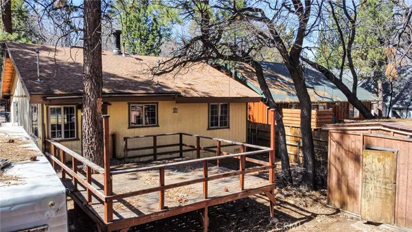 a view of a house with a tree and wooden fence