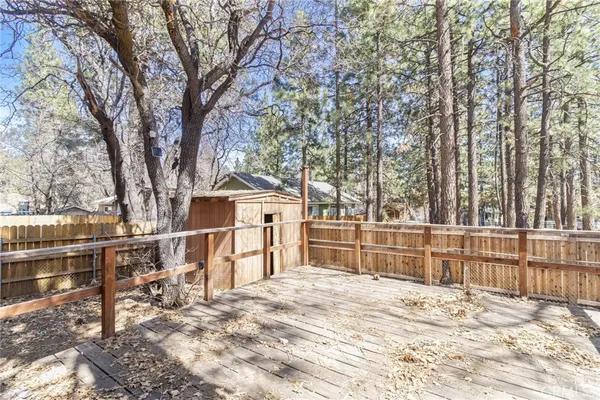 a view of a house with a wooden fence and a bench