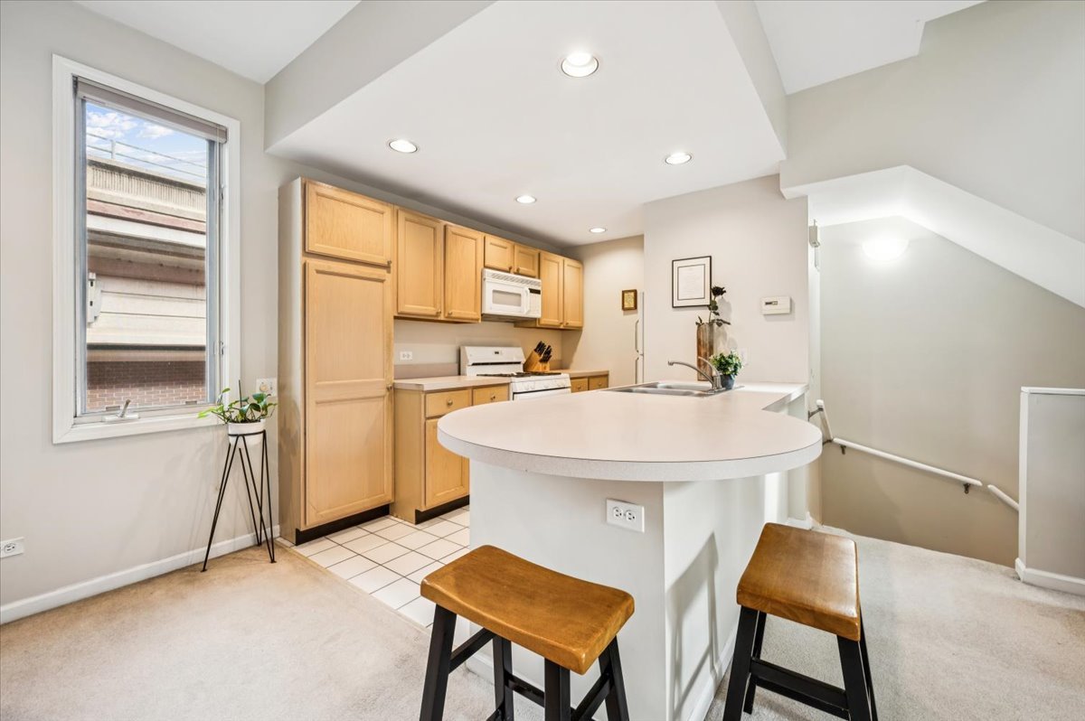 1200 South Federal Street, Unit D Chicago, IL 60605 - Photo 5 of 20 a kitchen with a table chairs refrigerator and window