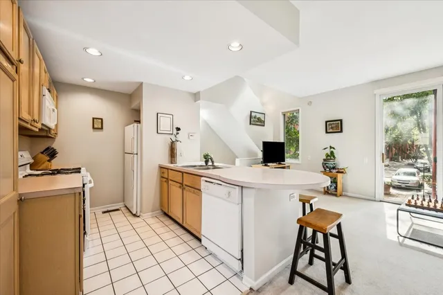 a kitchen with a stove a refrigerator and white cabinets