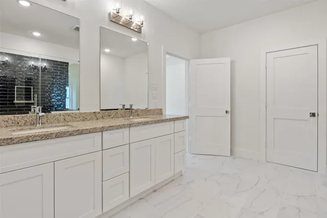 a bathroom with a granite countertop sink and a mirror