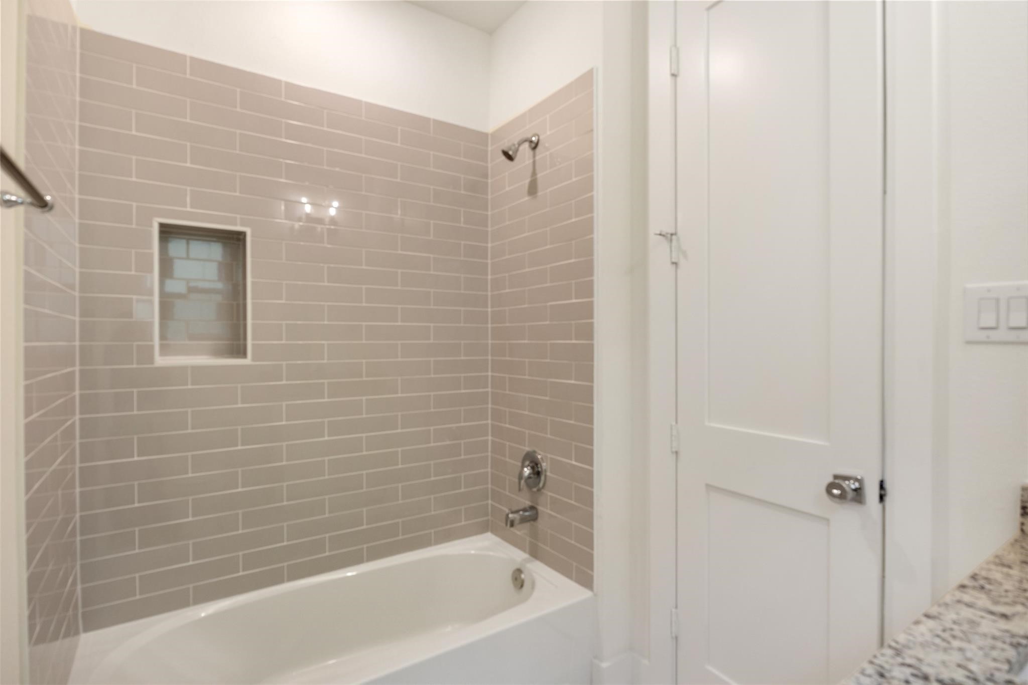 1928 Purswell Road Houston, TX 77055 - Photo 29 of 36 The secondary bedroom on the first floor features its own en-suite bathroom with a tub-shower combo and modern finishes.