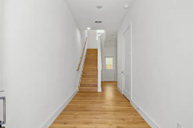 a view of a hallway with wooden floor
