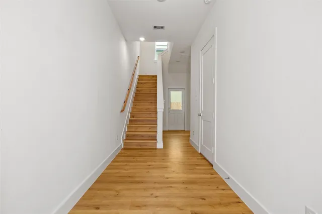 a view of a hallway with wooden floor