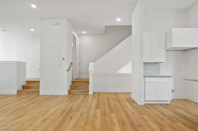 a view of empty room with wooden floor and stairs