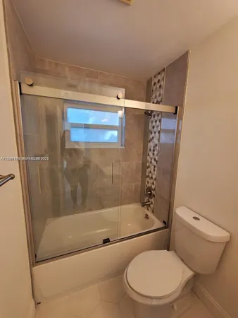a bathroom with a granite countertop sink mirror vanity and toilet