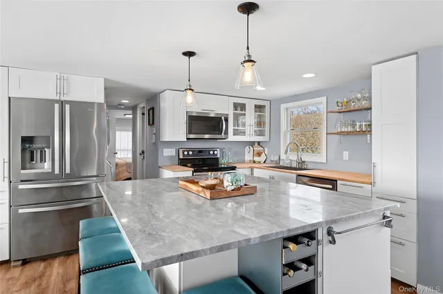 a kitchen with stainless steel appliances granite countertop a sink a stove and microwave