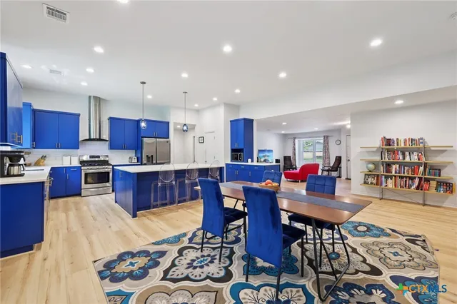 a living room with lots of furniture and kitchen view with wooden floor