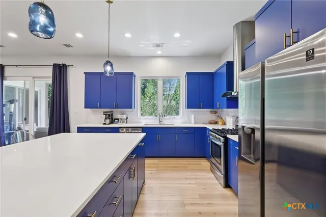 a kitchen with stainless steel appliances granite countertop a sink refrigerator and microwave