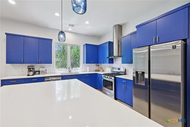 a kitchen with stainless steel appliances granite countertop a refrigerator a sink a stove a microwave and wooden cabinets