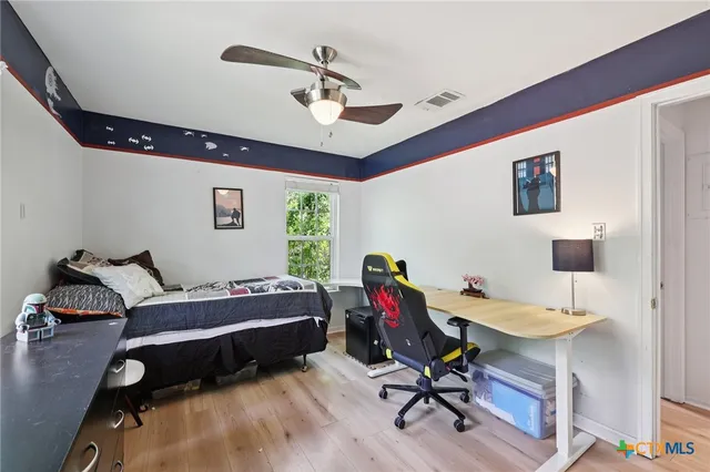 a bedroom with a bed and a chandelier