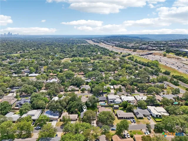an aerial view of residential houses with outdoor space and trees