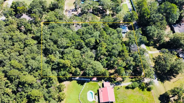 an aerial view of residential house with yard and outdoor seating