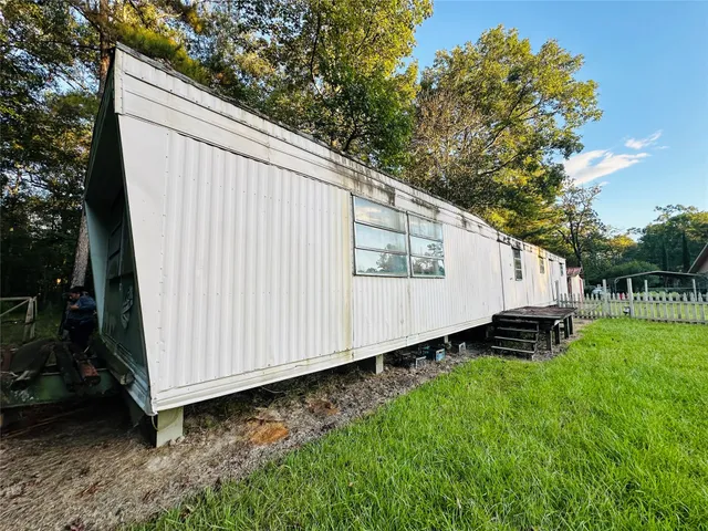 a backyard of a house with lawn chairs and a small yard
