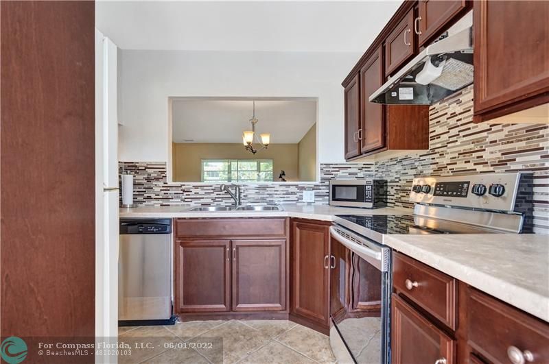 a kitchen with stainless steel appliances granite countertop a sink and a stove