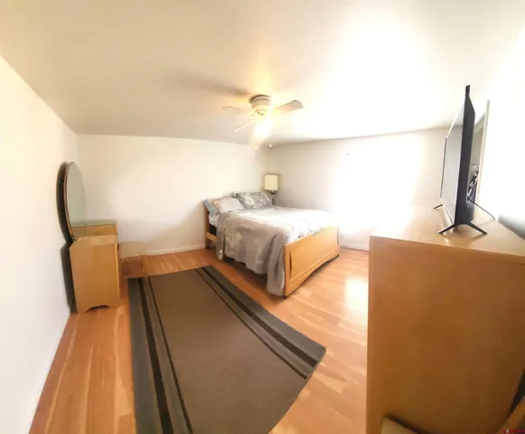 a bedroom with a bed and wooden floor
