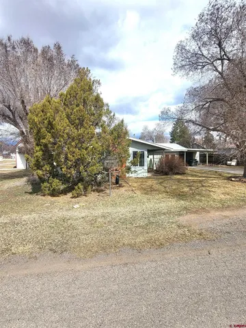 a front view of a house with a yard and trees
