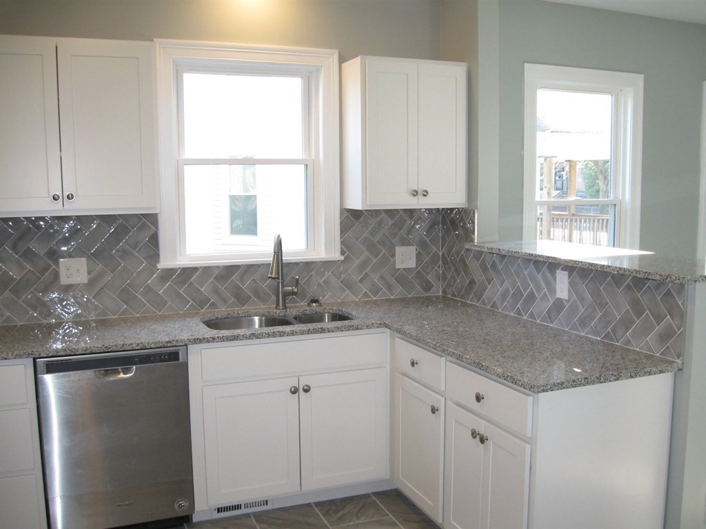 12 Alderman Street Springfield, MA 01108 - Photo 4 of 27 a kitchen with granite countertop white cabinets and a window