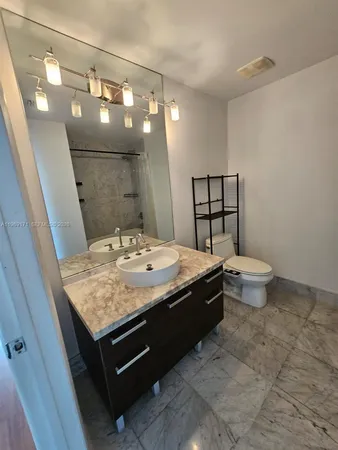 a bathroom with a granite countertop sink a mirror and a bathtub