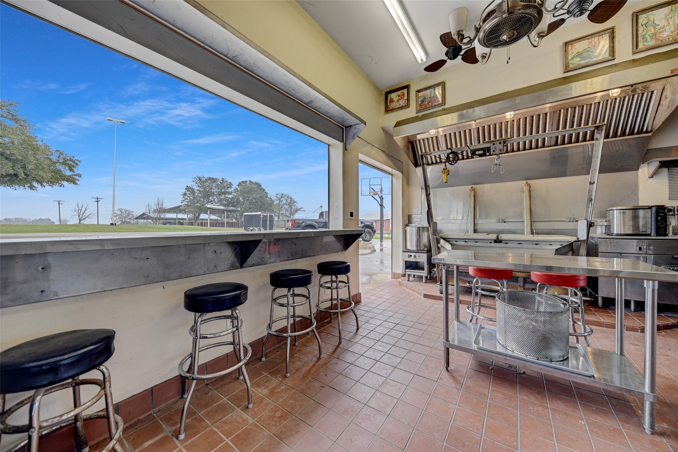 9950 Palestine Road Brenham, TX 77833 - Photo 33 of 49 The commercial grade outdoor kitchen also features a stainless steel sink, stainless steel serving ledge on two seperate sides, and storm shutters on the entrance and both serving areas to allow it to be fully enclosed or open to the beautiful property.