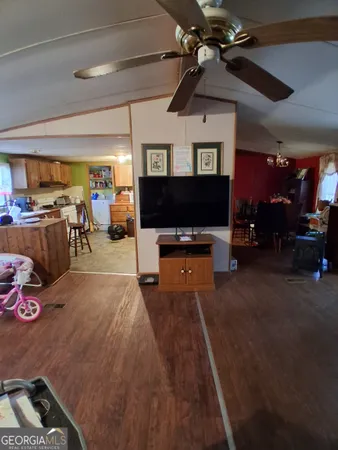 a living room with furniture a flat screen tv and kitchen view