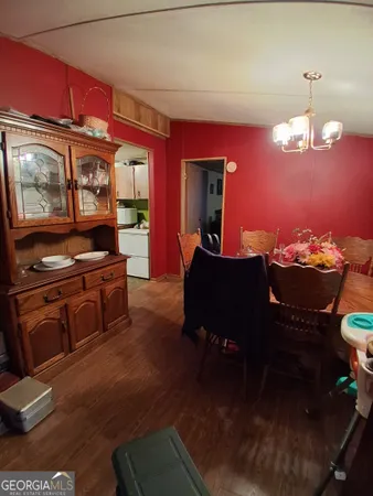 a view of a dining room with furniture a chandelier and wooden floor