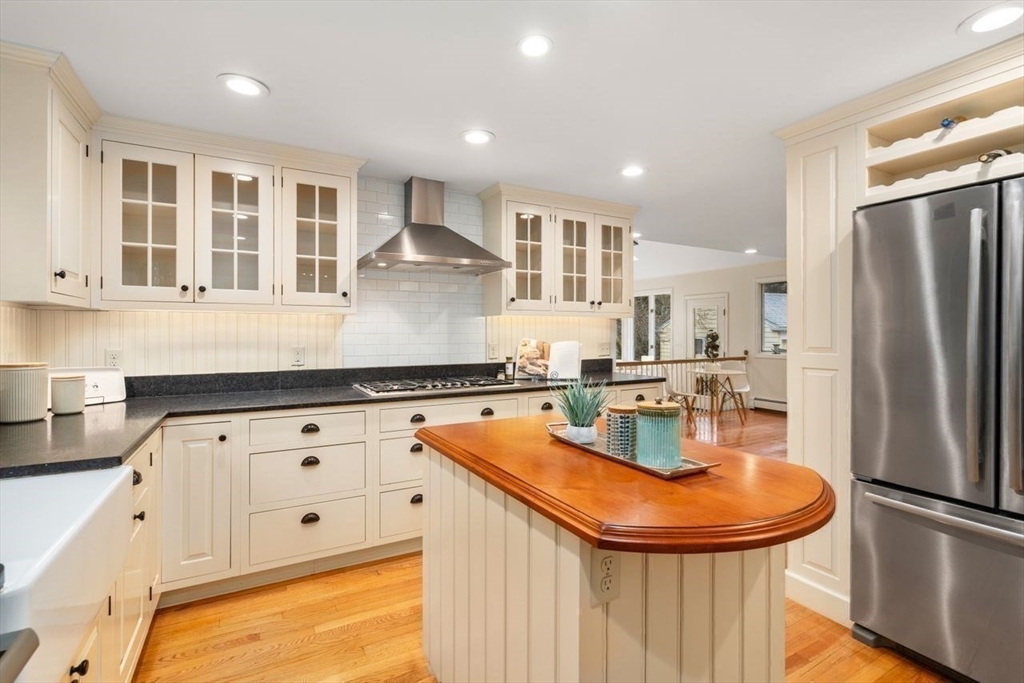 36 Rutledge Road Belmont, MA 02478 - Photo 11 of 23 a kitchen with stainless steel appliances granite countertop a refrigerator a sink dishwasher a stove and white countertops with wooden floor
