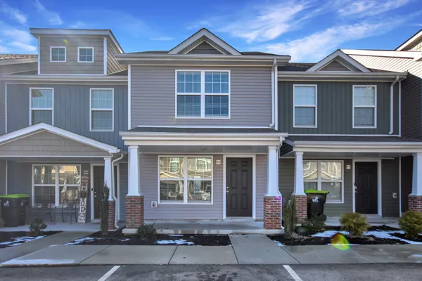 front view of a brick house with a small yard