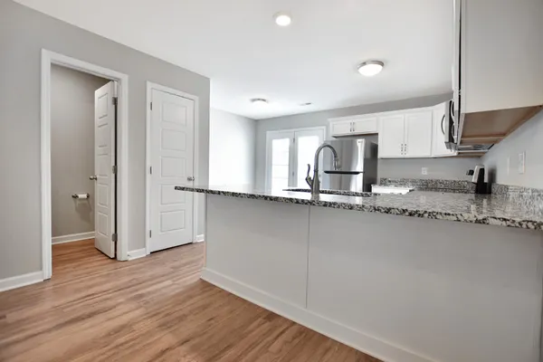 a kitchen with granite countertop a refrigerator and a sink