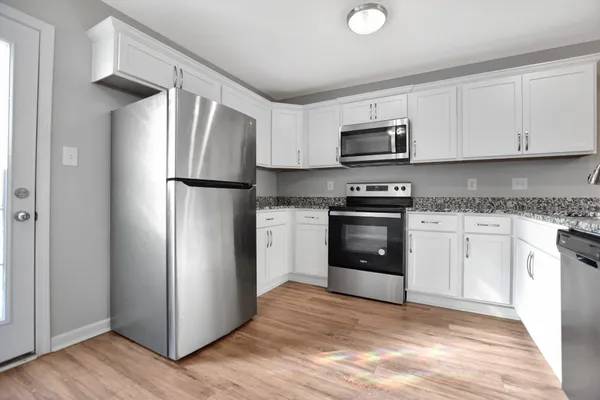 a kitchen with a refrigerator sink and stove top oven