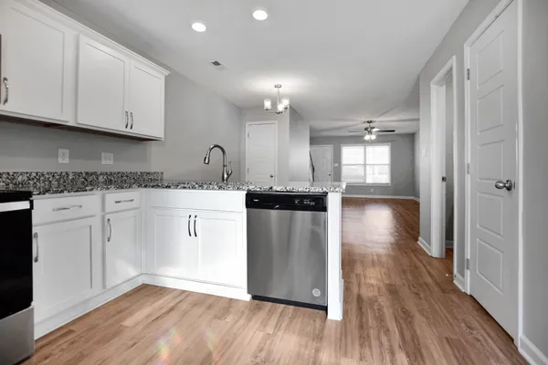 a kitchen with a refrigerator a sink and dishwasher with wooden floor