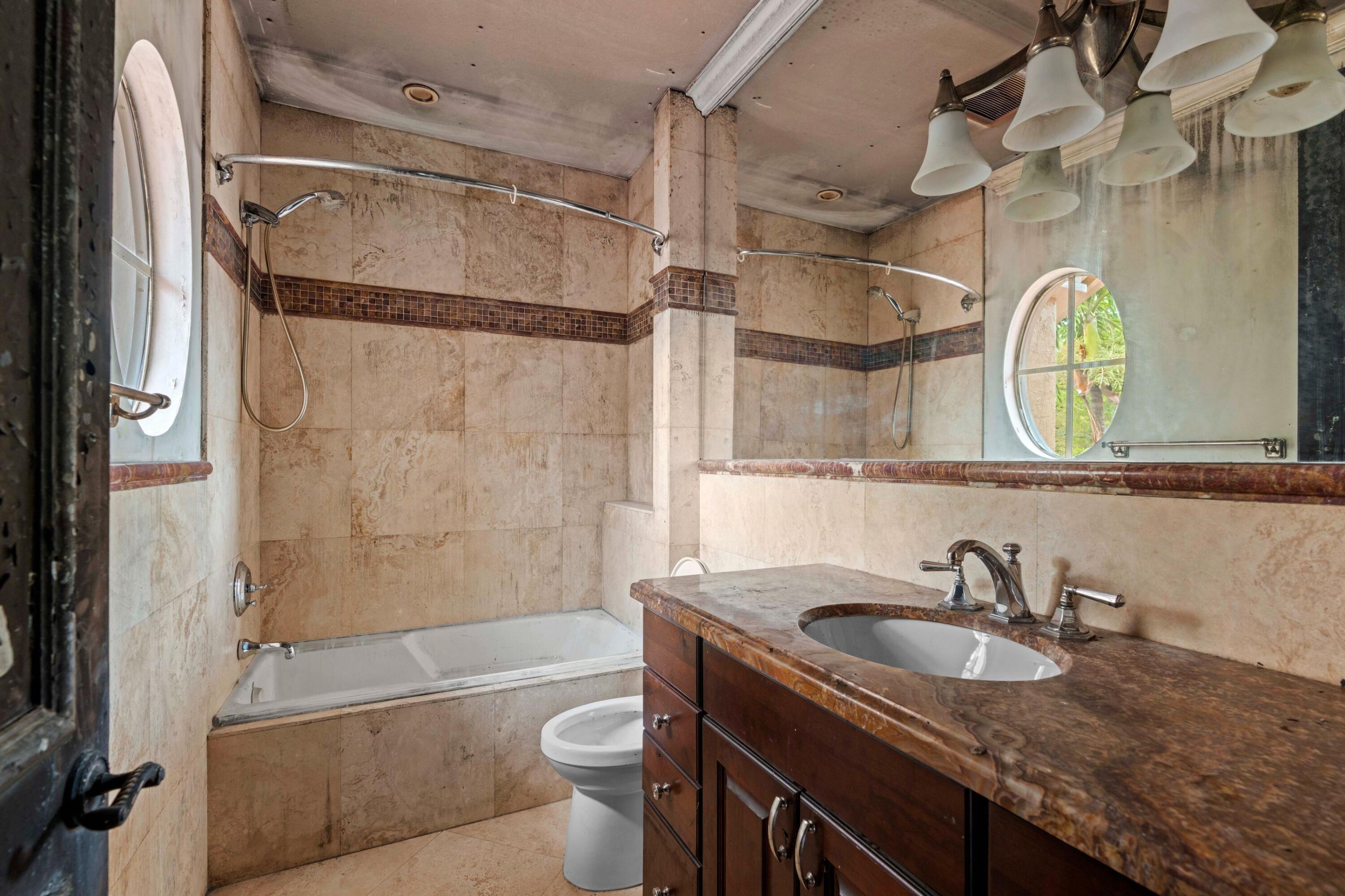 3054 Northwest 60th Street Boca Raton, FL 33496 - Photo 15 of 48 a bathroom with a granite countertop sink mirror toilet and bathtub