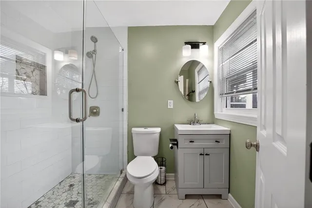 a bathroom with a granite countertop toilet sink and mirror