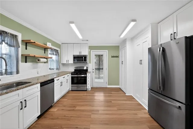 a kitchen with stainless steel appliances a refrigerator stove microwave and cabinets