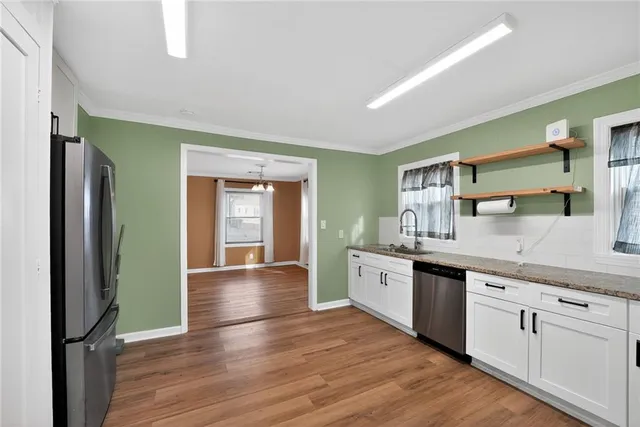 a large kitchen with stainless steel appliances granite countertop a refrigerator and a sink