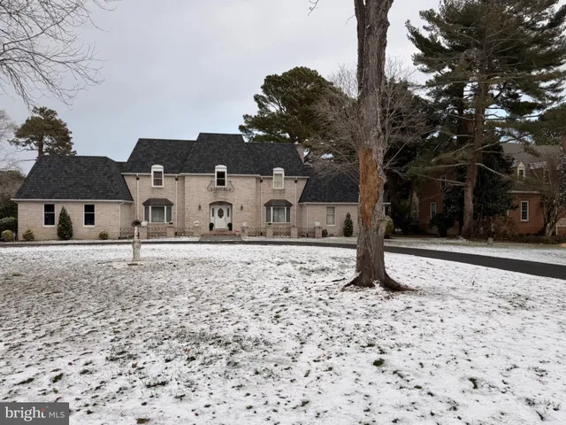 a front view of a house with a yard covered with snow